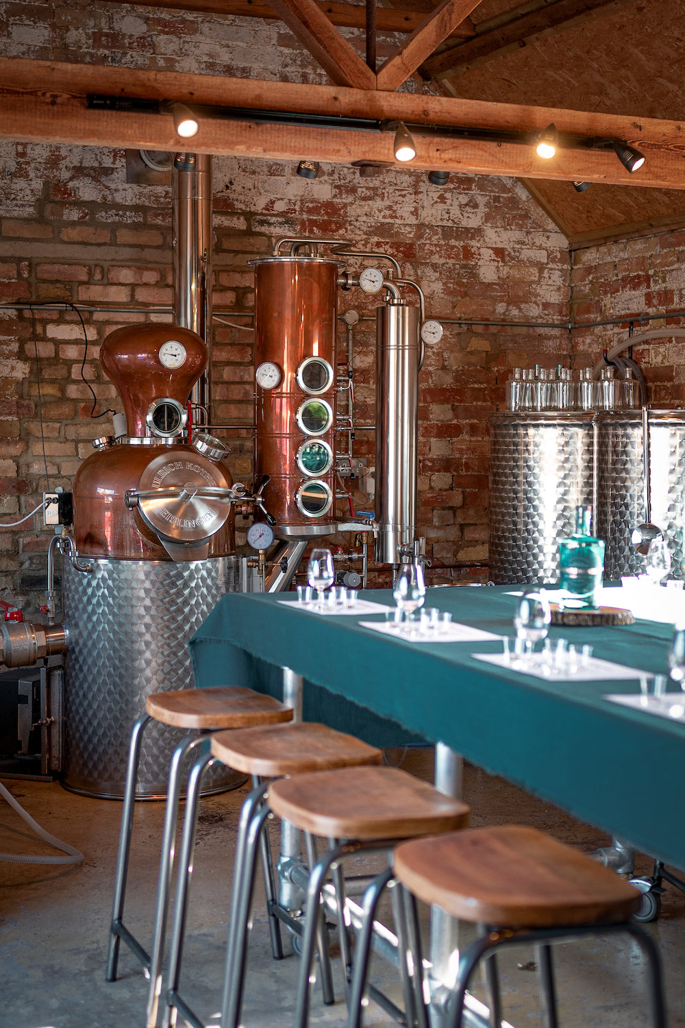 Copper still stood behind the tasting table, laid with tablecloth and tasting glasses