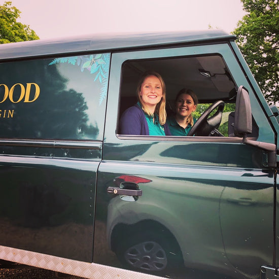 Emily and Ella smile from the window of branded Land Rover Defender, ready to attend summer events